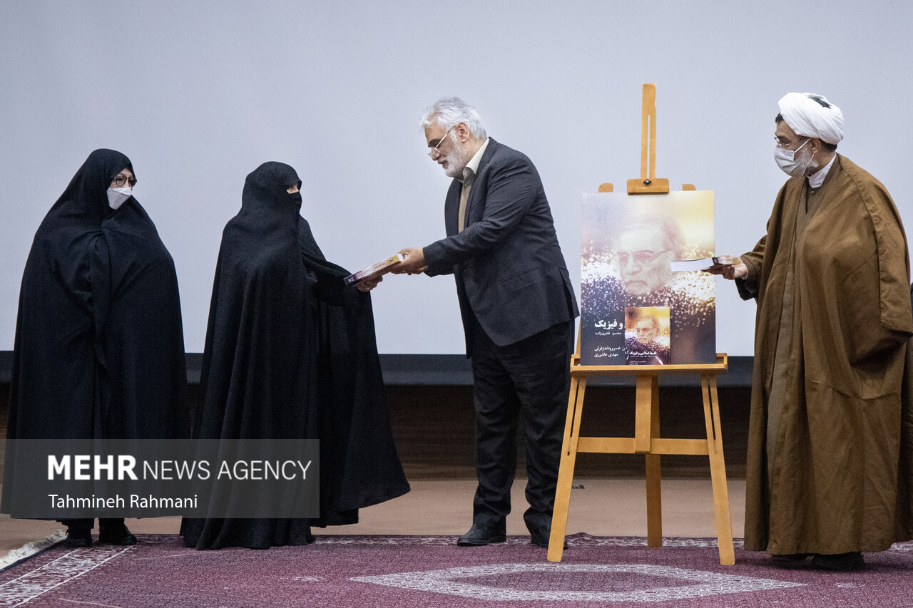 محمد مهدی تهرانچی، رییس دانشگاه آزاد اسلامی، بعد از مراسم رونمایی از کتاب" فلسفه اسلامی و فیزیک" این کتاب را به همسر شهید فخری زاده تقدیم می کند