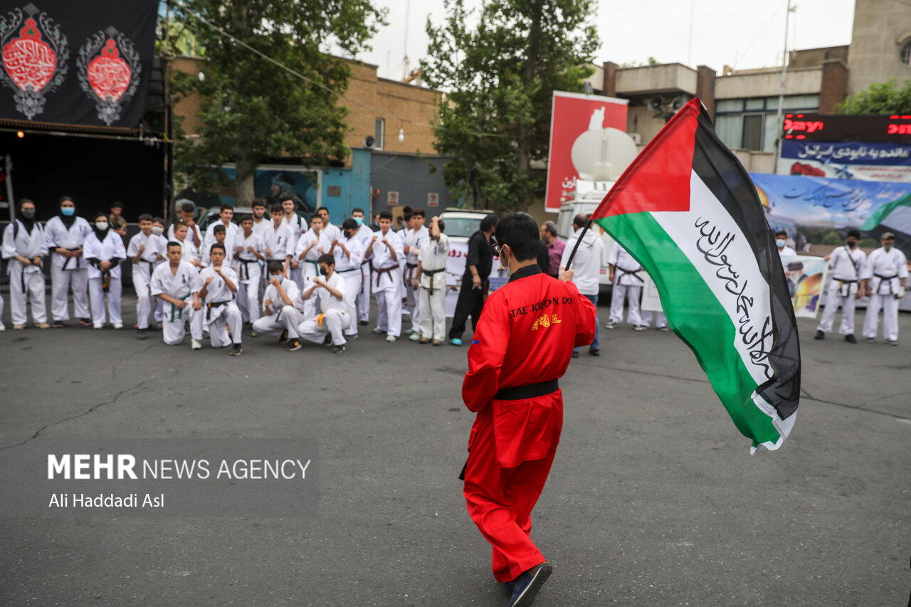 جوان رزمی کاری با برافراشتن پرچم فلسطین در راهپیمایی روز جهانی قدس در تهران حضور دارد