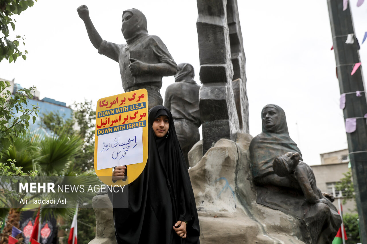 دختر جوانی با برافراشتن تابلوی مرگ بر اسرائیل در مراسم راهپیمایی روز جهانی قدس در تهران حضور دارد