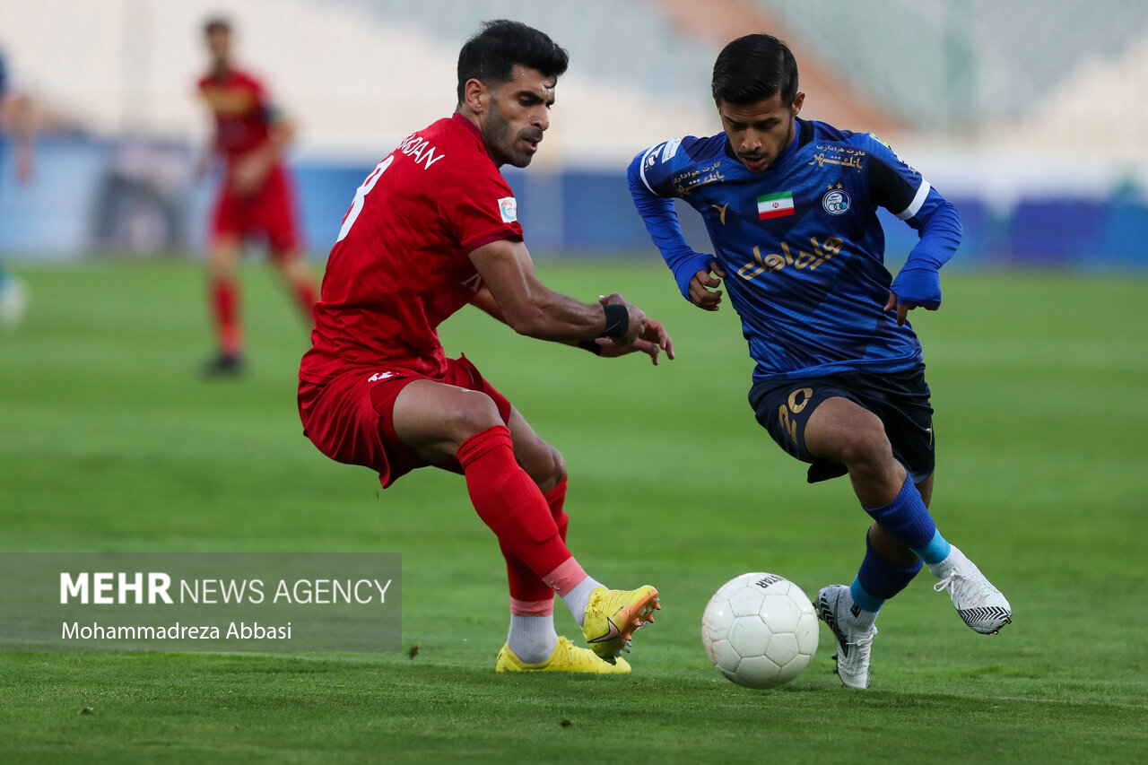 مهدی قاییدی بازیکن تیم فوتبال استقلال تهران در حال عبور توپ از بازیکن تیم فوتبال فولاد خوزستان در دیدار تیم های فوتبال استقلال تهران و فولاد خوزستان است